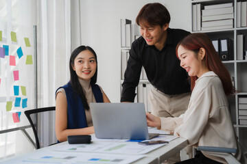 Collaborative Teamwork: A diverse team of young Asian professionals engages in a productive...