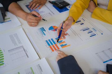 Data Driven Decisions:  A close-up view of a team of business professionals collaborating over a table, analyzing charts and graphs.
