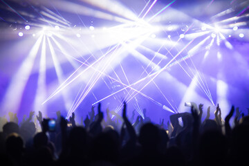 Crowd at concert and colorful stage lights.