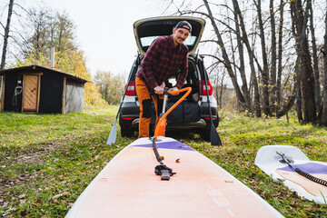 An adventurous paddleboarder is eagerly getting ready for an exciting day ahead, filled with fun...