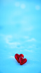 Fototapeta premium Two red hearts in snow