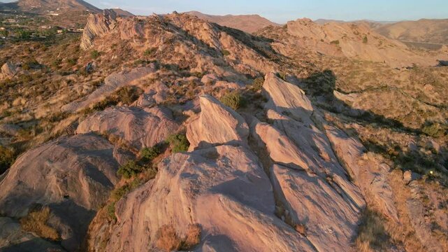Aerial view rising over sunlit desert rocks in the Vasquez natural park, USA
