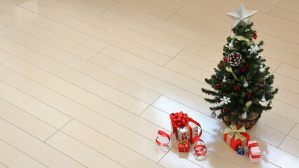 Christmas background: Christmas tree and gift boxes on the wooden floor of the room