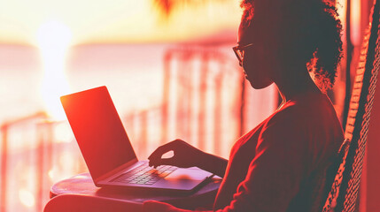 silhouette of person working on laptop during sunset, creating serene and inspiring atmosphere. warm colors of sunset enhance tranquil setting, perfect for remote work