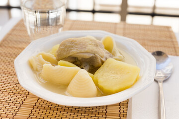 Chicken broth soup with chicken, potatoes, and pasta shells