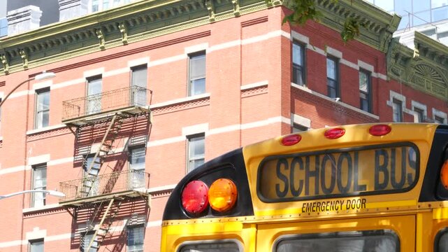 Yellow School Bus on New York Manhattan street, schoolbus truck on city road. Children education and transportation, USA. American school shuttle, 10 avenue Chelsea red brick house, United States.
