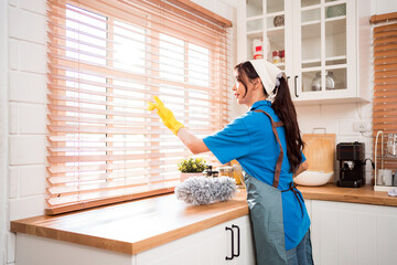 Asian young professional cleaning service woman worker working in the house. The girl cleans the...