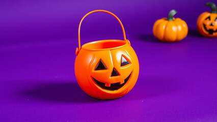 Close-up of a Smiling Jack-o'-Lantern Halloween Trick-or-Treat Bucket on a Purple Background