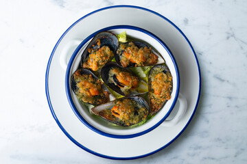 Mussels au gratin with parsley, oil and bread. Top view table with decorations.