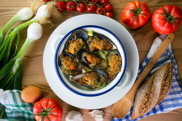 Mussels au gratin with parsley, oil and bread. Top view table with decorations.