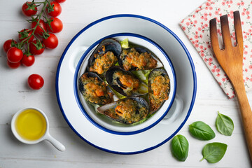 Mussels au gratin with parsley, oil and bread. Top view table with decorations.