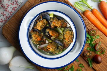 Mussels au gratin with parsley, oil and bread. Top view table with decorations.