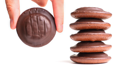 Hand Holding Chocolate Cookie Next to Stacked Cookies on White Background