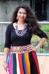 woman in stylish and modern navratri look with heavy neckless and multi color chaniya - lehengha - ghaghra for garba and dandiya in Navratri. Happy smiling gujarati indian girl in traditional outfit