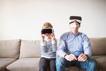 Boy and grandpa trying VR headset. Grandfather spending time with grandson, taking care of him...