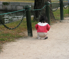 cute baby squatting on the ground, back view