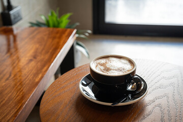 Hot coffee latte with latte art milk foam in cup mug on wood desk on top view. As breakfast In a coffee shop at the cafe,during business work concept,vintage style
