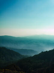 Aerial view of lush green hills with sun rays piercing through cloud, Kelimutu mountains, East Nusa Tenggara province, Indonesia