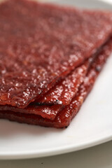 sliced sheets of dried and crispy pork, close up. Bak kwa isolated on white background