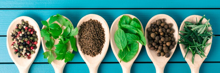 Various spices on wooden spoons