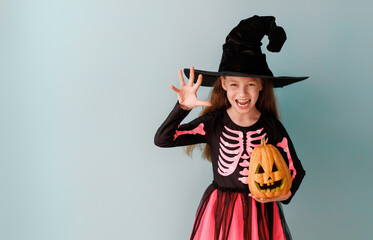 girl in witch costume with Halloween pumpkin