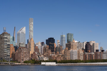 Obraz premium New York City skyline with skyscrapers and waterfront on a clear day.