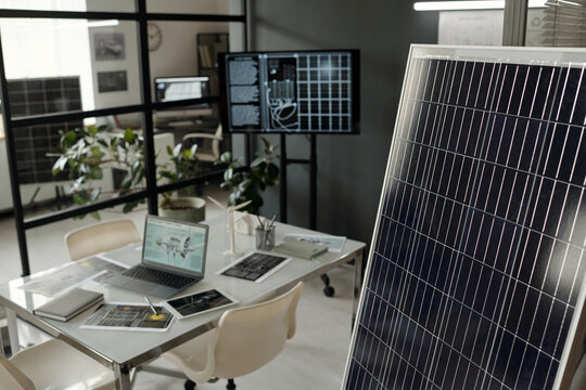 Mockup of solar panel standing in office against workplace of architect with documents and mobile gadgets