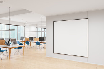 Blank framed poster mockup displayed on a white wall in a modern office with desks, chairs, and computers. Concept for office interior design. 3D Rendering