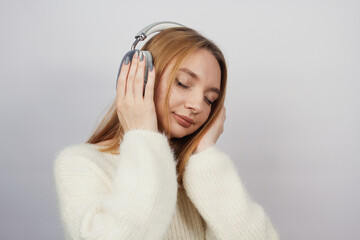 Girl listening to music on headphones on white background