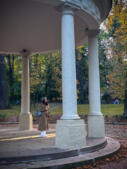 Person standing under gazebo in autumn park