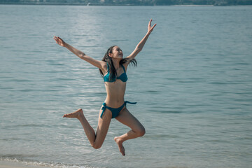 Woman jumping on beach free and happy