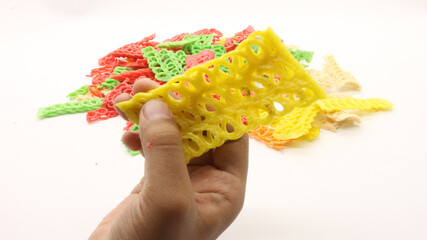 Hand holding colorful crackers or krupuk unfired isolated
