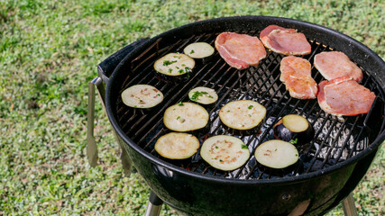 Grilling meat and vegetables on a charcoal barbecue in the backyard, perfect for summer cookouts and family gatherings