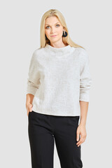 Stylish woman in a white sweater and black trousers posing on white background