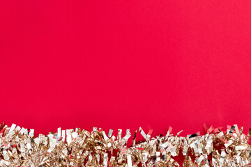 Shiny gold Christmas ornament on red textured background