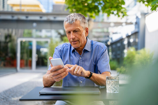 Businessman using smart phone at table