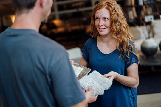Woman holding carpet samples and discussing with vendor at store