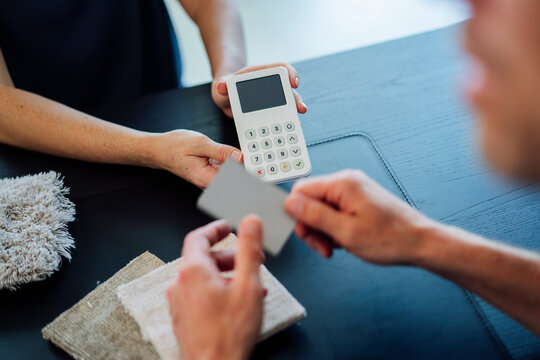Saleswoman holding credit card reader at checkout