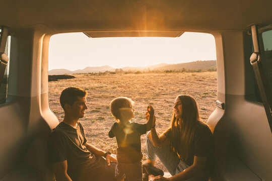Parents spending leisure time with son in car trunk