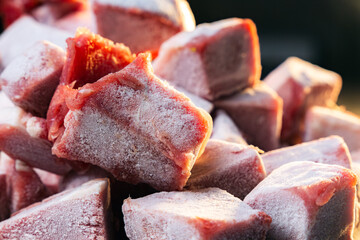 pile of frozen meat cube on a stainless steel table, closed up