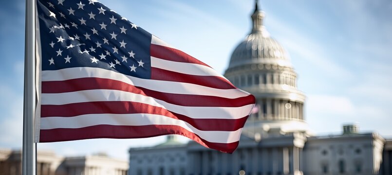 American flag waving in front of the United States Capitol building on a clear sunny day