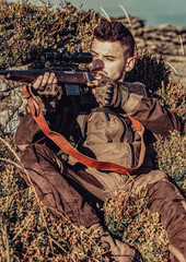 Hunter is aiming. Shooter sighting in the target. The man is on the hunt