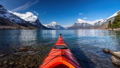 Kayaking in the spring by snow covered mountains on Lake McDonald in Glacier National Park 