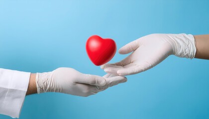 Fototapeta premium Hands in gloves exchanging a red heart symbol, blue background.