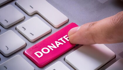 Finger pressing pink donate button on a keyboard, white background.