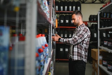 seller man with canister of motor oil in auto store