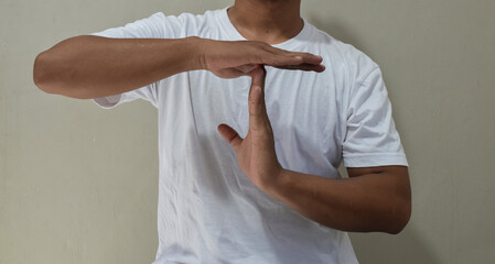 Young man showing a pause time out gesture with hands