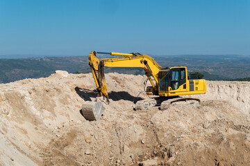 Escavadora de esteiras na construção de uma barragem para armazenamento de água para rega...