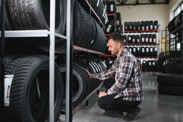 Man chooses winter car tires in the auto shop © Serhii