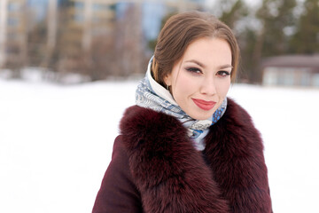 A woman wearing a red fur coat and a scarf